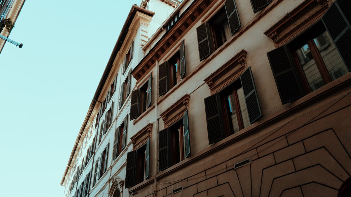 A captivating upward view of historic Roman buildings with open shutters showcasing classic architecture.